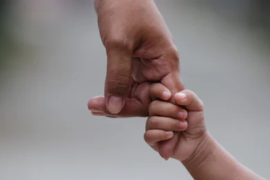 Child holding adult finger